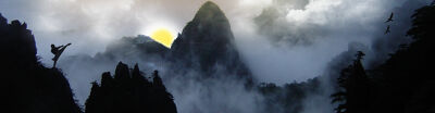 Shaolin Mönch trainiert in nebeliger Berglandschaf bei Sonnenaufgang